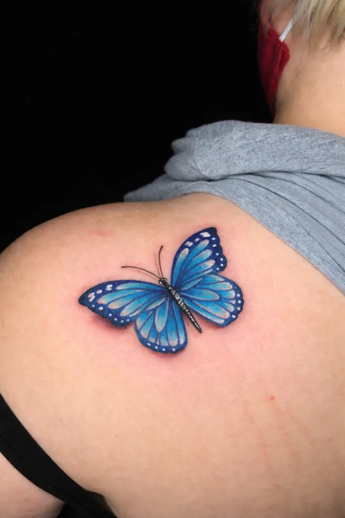 Tatuagem colorida de borboleta azul